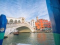 Venice, Italy - 17.10.2023: Stunning Rialto bridge over the Grand channel and gondola with tourists under the bridge. Travel and Royalty Free Stock Photo