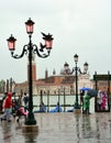 Tourists on a rainy day in Piazza San Marco St Marks Square.