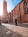 Venice, Italy - 17.10.2023: tourists sightseeing old magnificent buildings. Sun flare, red color bricks of the walls. Sun flare
