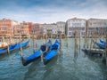 Venice, Italy - 17.10.2023: Traditional gondolas by The Grand channel in Rialto Bridge area. Warm sunny day, blue cloudy sky.