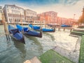 Venice, Italy - 17.10.2023: Traditional gondolas by The Grand channel in Rialto Bridge area. Warm sunny day, blue cloudy sky.