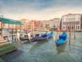 Venice, Italy - 17.10.2023: Traditional gondolas by The Grand channel in Rialto Bridge area. Warm sunny day, blue cloudy sky.