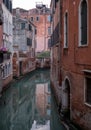 Typical canal scene in Venice with reflection in the water. Royalty Free Stock Photo
