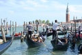 Venice lagoon with a queue of gondolas with tourists sitting in them and the island of San Giorgio Maggiore.