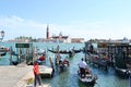 Venice lagoon with a queue of gondolas with tourists sitting in them and the island of San Giorgio Maggiore.