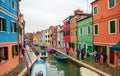 Venice landmark, Burano island canal, colorful houses church and boats, Italy.