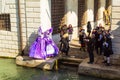 Venice Masquerade characters posing near canal Italy