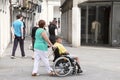 VENICE, MESTRE-June 29, 2014: Woman pushing a senior man in a wheelchair. VENICE, MESTRE-June 29, 2014. Mestre is the most