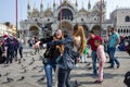 Venice - October 04: Unknown female tourists have fun with pigeons on the Piazza San Marco on October 04, 2017 in Venice