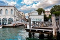 Venice with a pier on the foreground, water reflections, an small bridge with people walking Royalty Free Stock Photo