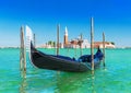 Venice seascape with gondola at wooden bricole mooring against famous San Giorgio Maggiore island and church in sunny day. View Royalty Free Stock Photo