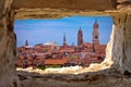 Venice towers and rooftops view through stone window