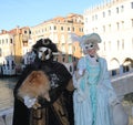 Venice, VE, Italy - February 13, 2024: couple of masked people and a dog on the rialto bridge during the carnival