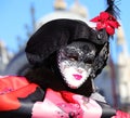 Venice, VE, Italy - February 13, 2024: masquerade woman with lipstick and white mask during the Venetian carnival