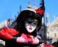 Venice, VE, Italy - February 13, 2024: masquerade woman with lipstick and white mask during the Venetian carnival