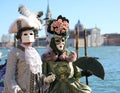 Venice, VE, Italy - February 13, 2024: nobles dressed in masks during carnival and adriatic sea in background
