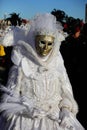 Venice, VE, Italy - February 13, 2024: person with an ancient golden mask and embroidered white dress at the carnival Royalty Free Stock Photo