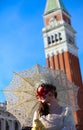 Venice, VE, Italy - February 13, 2024: pretty girl with red mask and lipstick and umbrella Royalty Free Stock Photo