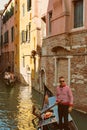 VENICE, VENETO, ITALY - Gondoliers and tourists, gondola riding, typical canal in Venice