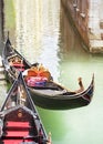 Venice vertical street view cityscape, Italy, Europe.Gondolas at their moorings close-up in water of small beautiful canal. Text