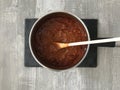 Venison Bolognese sauce in a pan on a wooden background