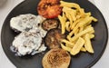 Venison burgers with cabrales sauce, fried potatoes and grilled tomato, onion and aubergine, Spain