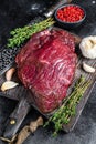 Venison raw deer meat on a cuuting board with herbs. Black background. Top view Royalty Free Stock Photo