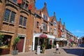 Beautiful dutch shopping street, typical old historic gabled brick houses, blue summer sky