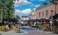 Market square with outdoor gastronomy in summer in dutch town, green linden trees