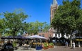 Market square with outdoor gastronomy in summer in dutch town, green linden trees