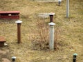 Vent pipe sticks out of the ground. Pipe for ventilation of the cellar. A rusty pipe sticks out of the ground on the river bank on