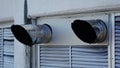 Ventilation ducts mounted on exterior wall with protective covers visible Royalty Free Stock Photo