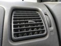 Ventilation grill in the passenger compartment. Gray car interior. Car engine grill with rust