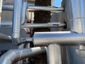 Ventilation pipes in silver insulation material hanging from the ceiling inside new building. Modern industrial factory Royalty Free Stock Photo