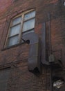 Ventilation system in an abandoned building against brick wall