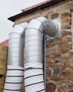 Ventilation system with silver pipes sticking out of the building