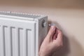 Venting the radiator. The man`s hand holds a special key which he inserts into the vent valve.