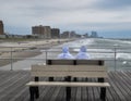 Ventnor City, New Jersey- September, 2021: Two nuns in white habits sitting on a wooden pier looking out at a rough ocean