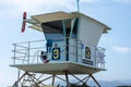 A lifeguard at Ventura Harbor watches from inside a lifeguard tower at a breakwater