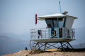 A lifeguard at Ventura Harbor watches from inside a lifeguard tower at a breakwater