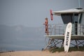 A female lifeguard at Ventura Harbor stands watch from a lifeguard tower