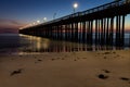 Ventura Pier at Sunset. Beach in foreground, smooth ocean; colored sky in background. Royalty Free Stock Photo