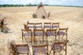 Venue for a wedding ceremony in rustic style in a rural place. Triangular wooden arch decorated with flowers in a golden, mown Royalty Free Stock Photo