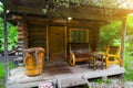 The veranda of a small wooden bathhouse on the porch of which there are benches and a large old bath. Rest and health in nature