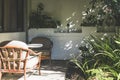 Veranda with wooden chairs on a sunny day. Shaded patio with plants