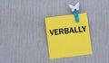 VERBALLY - words on yellow paper with clothespin on gray background Royalty Free Stock Photo