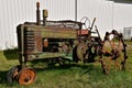 Old John Deere tractor missing a front tire