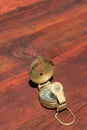 Verical of a lensatic compass on a wooden table.