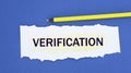 VERIFICATION - word on a torn white paper on a blue background Royalty Free Stock Photo