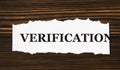 VERIFICATION - word on a white tattered piece of paper on a wooden background Royalty Free Stock Photo